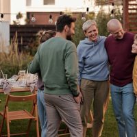 Father’s Day Backyard Makeover depicted by a outdoor meal with family members talking and hugging
