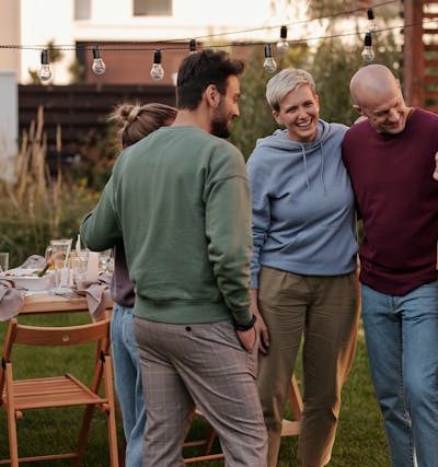 Father’s Day Backyard Makeover depicted by a outdoor meal with family members talking and hugging
